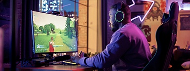 un joueur sur son bureau avec un jeu de tir PVP sur son écran à la maison