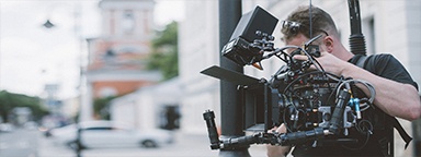 Professioneller Videofilmer bei Filmaufnahmen in einem Gebäude
